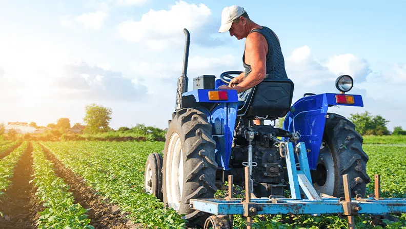 Agricultor trabaja sobre tractor